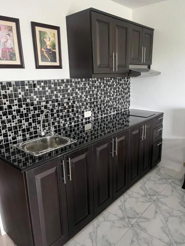a kitchen with a sink and a black tiled counter at Sea sand Sun condominium 415 in Thang Kwian