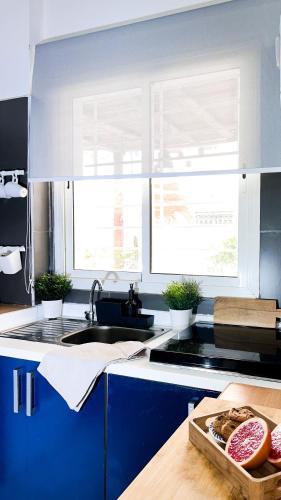 a kitchen with blue cabinets and a sink with donuts at Appartamento Fronte al Mare in Tangier