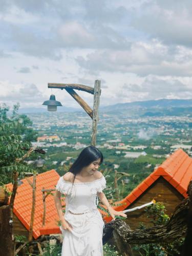a woman in a white dress standing on top of a mountain at Dreamers Garden Farmstay in Hoat