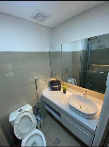 马尼拉Stunning Hotel Feels at Shore的浴室里有洗手池、马桶和镜子。