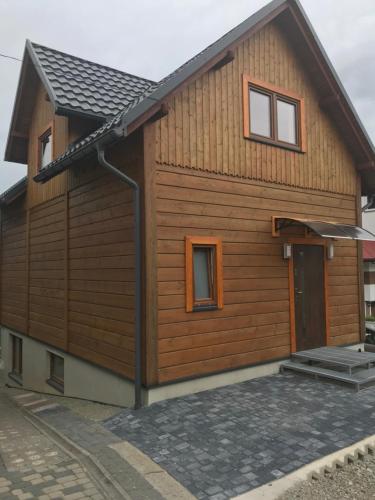 a house with wooden siding and a door at Domek nad Soliną in Solina