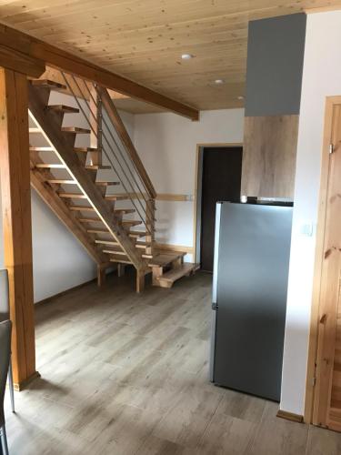 a kitchen with a staircase and a refrigerator at Domek nad Soliną in Solina