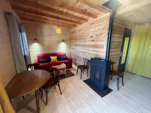 un salon avec un canapé rouge et une table dans l'établissement Les gîtes de Sainte Croix, à Sainte-Croix-Vallée-Française