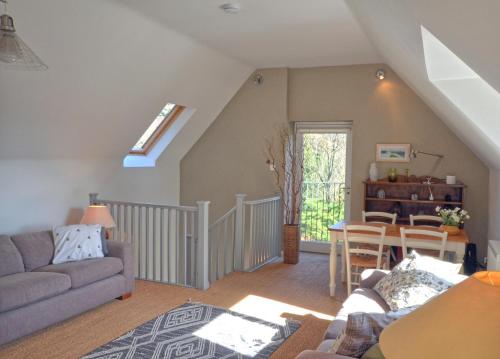 Black Barony Home Farm Cottage في إيدلستون: غرفة معيشة بها أريكة وطاولة