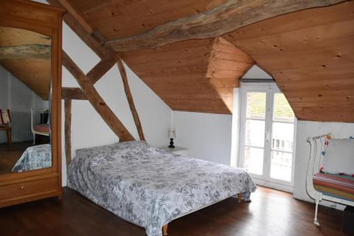 une chambre avec un lit dans une pièce avec des plafonds en bois dans l'établissement La Maison des Tilleuls, à Mont-près-Chambord