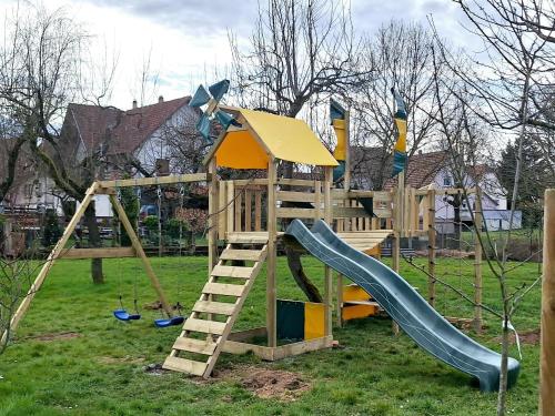 - une aire de jeux en bois avec un toboggan et une échelle dans l'établissement Chez Mado, à Hatten