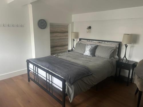 a bedroom with a bed and a clock on the wall at Spacious studio with free EV recharge overnight in Watford