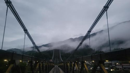 a bridge over a city with a foggy mountain at tsumugi tei in Nagiso