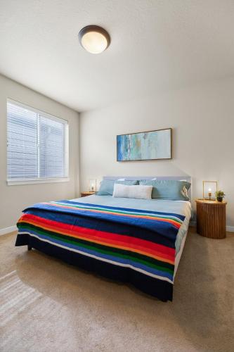 a bedroom with a large bed with a colorful blanket at THE PENDLETON - Walkable - Arcade Loft - Modern- Light & Bright in Eugene