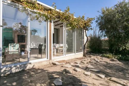 une véranda avec des portes vitrées et une terrasse dans l'établissement Maison avec jardin clos dans residence, à Gruissan