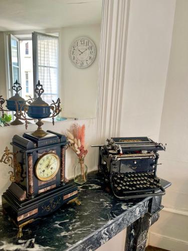 une chambre avec une vieille machine à écrire et une horloge sur le mur dans l'établissement Le Repos Poitevin Studio Atypique, à Vivonne