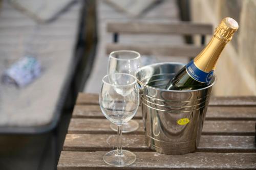 a bottle of champagne and two glasses on a table at Mandera's Boutique Suites & Dorms in Valletta