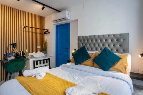 a bedroom with a large bed with a blue door at Mandera's Boutique Suites & Dorms in Valletta