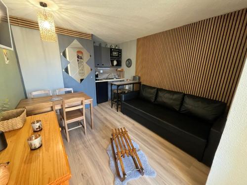 un salon avec un canapé noir et une table dans l'établissement Le Galibier 3, à Les Deux Alpes
