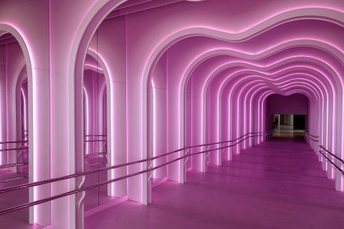 a hallway with purple walls and a heart shaped tunnel at SLS Barcelona in Barcelona