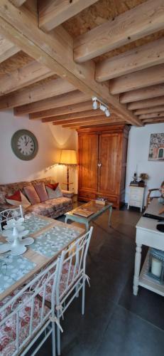 un soggiorno con un tavolo e un orologio a parete di Cottage tout équipé 2 à 4 personnes a Hérin