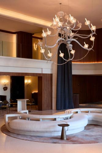 a lobby with a chandelier in the middle of a room at SLS Barcelona in Barcelona