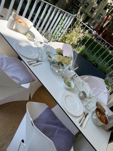 a white table with plates and dishes on it at Design apartment with river view in Düsseldorf