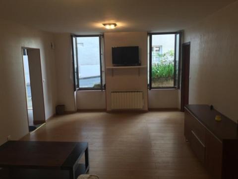 an empty living room with a tv and a couch at CHAPELLE ST NICOLAS in Roanne