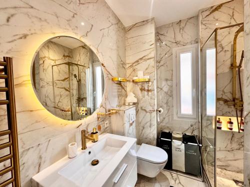 une salle de bain avec un lavabo et un miroir dans l'établissement Appartement vue mer vue Monaco, à Beausoleil