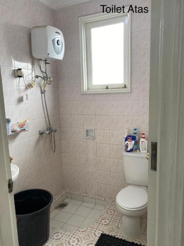 a small bathroom with a toilet and a window at Via puncak resort in Cikundul