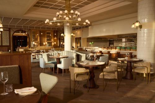 a restaurant with tables and chairs and a chandelier at SLS Barcelona in Barcelona