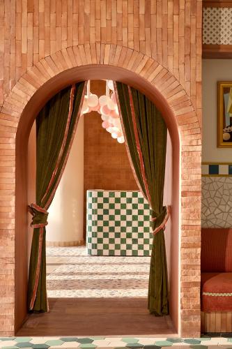 an archway with curtains in a room with a table at SLS Barcelona in Barcelona