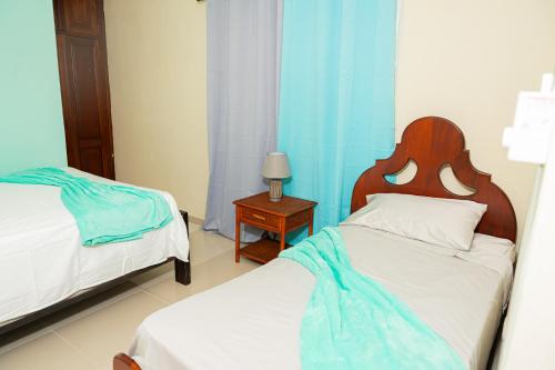 a bedroom with two beds and a table with a lamp at Rancho Juliana in Villas del Mar