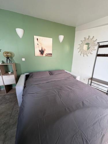 une chambre avec un grand lit dans une pièce dans l'établissement Cocoun, à Cambrai