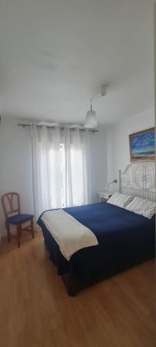 a bedroom with a blue bed and a chair at Apartamento Azul in Nerja