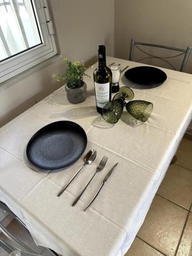 a table with two plates and a bottle of wine at Lupin Fodele Home near the beach in Fodele