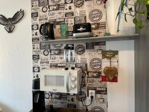 a wall with a microwave on top of it at Moderne und komfortable Appartements im Ferienpark Hahnenklee in Hahnenklee-Bockswiese