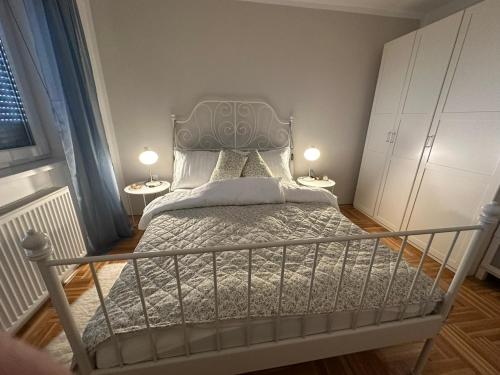 a bedroom with a bed with two lamps on two tables at APARTMENT CENTRAL No 5 in Apatin