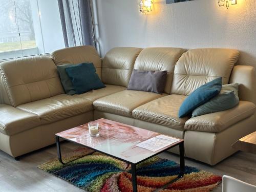 a living room with a couch and a coffee table at Moderne und komfortable Appartements im Ferienpark Hahnenklee in Hahnenklee-Bockswiese