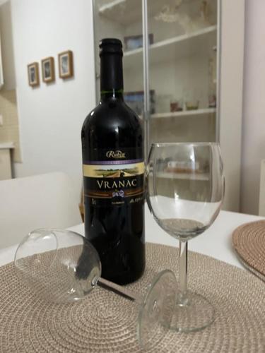 a bottle of wine and a wine glass on a table at APARTMENT CENTRAL No 5 in Apatin