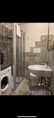 a bathroom with a toilet and a sink and a washing machine at Favignana Holidays 4 in Favignana