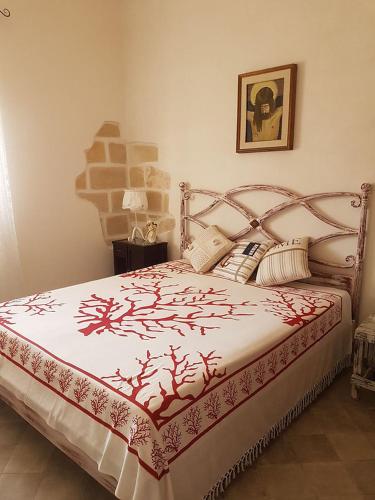 a bedroom with a bed with a red and white blanket at Favignana Holidays 4 in Favignana