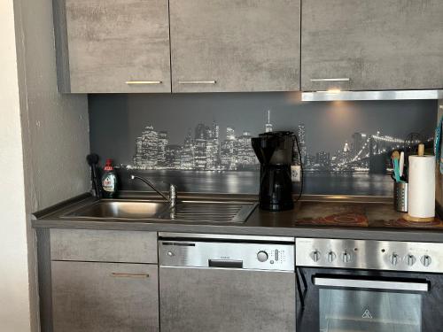a kitchen with a sink and a stove top oven at Moderne und komfortable Appartements im Ferienpark Hahnenklee in Hahnenklee-Bockswiese