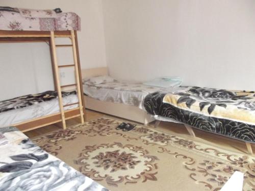 a room with two bunk beds and a rug at Khan House in Sheki