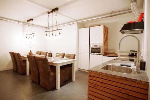 a kitchen with a table with chairs and a sink at Two Tulips Inn Dutch Retreat in Hillegom