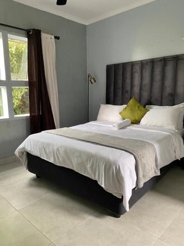 a bedroom with a large bed with a gray headboard at Cozy two bedroom apartment with Study in Sandton