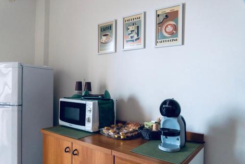 a kitchen counter with a microwave and a refrigerator at DV holiday home in Isola delle Femmine