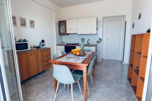 a kitchen with a wooden table and blue chairs at DV holiday home in Isola delle Femmine