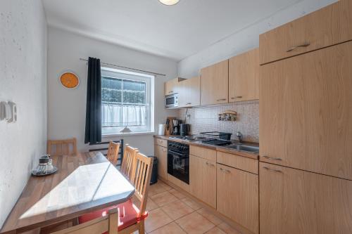 a kitchen with wooden cabinets and a table and a tableablish at Apartmány Happy Klínovec in Loučná pod Klínovcem