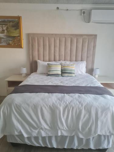 a large white bed with two pillows on it at Divine villa in Louis Trichardt