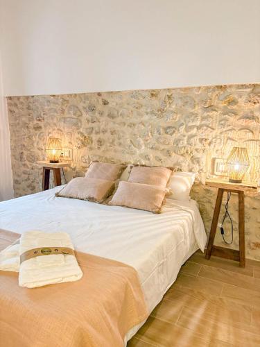 a bedroom with a large white bed with two lamps at Casa Rural Sant Roc in Murla
