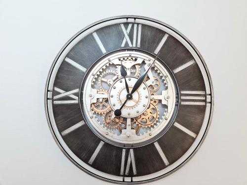 a clock with roman numerals on a wall at Dans les Nuages - Entrée autonome - Mulhouse Centre in Mulhouse