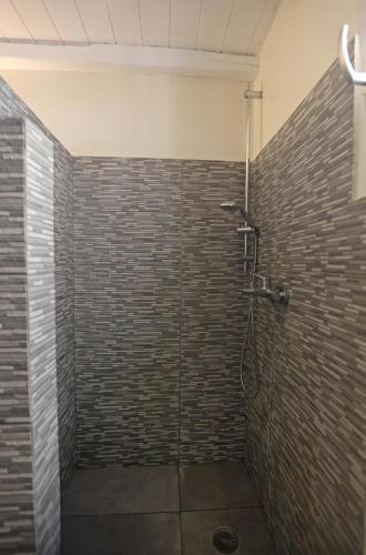 a bathroom with a shower with a brick wall at Thealos view in Ermoupoli