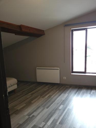 an empty room with a large window and a bed at CHAPELLE ST NICOLAS in Roanne