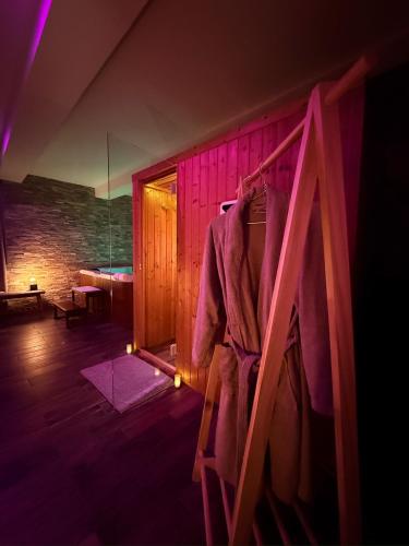 Cette chambre comprend un peignoir accroché au mur. dans l'établissement L'Évasion Étoilée - Jacuzzi Spa Sauna Hammam - ex CosyKaza, à Bray-sur-Somme